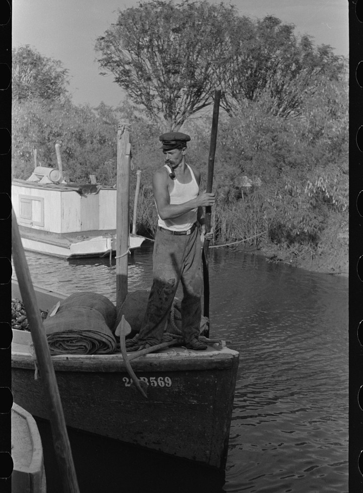 Poling an oyster boat to the dock, Olga, Louisiana, 1938